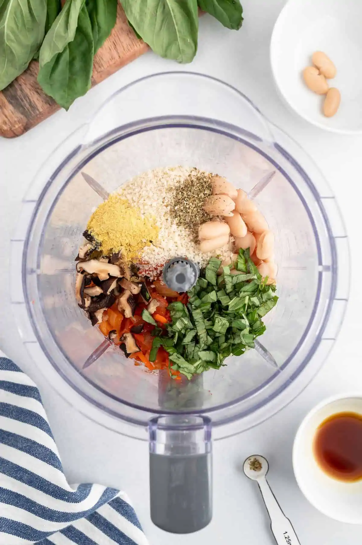 A top-down shot of veggie meatball ingredients in a food processor.