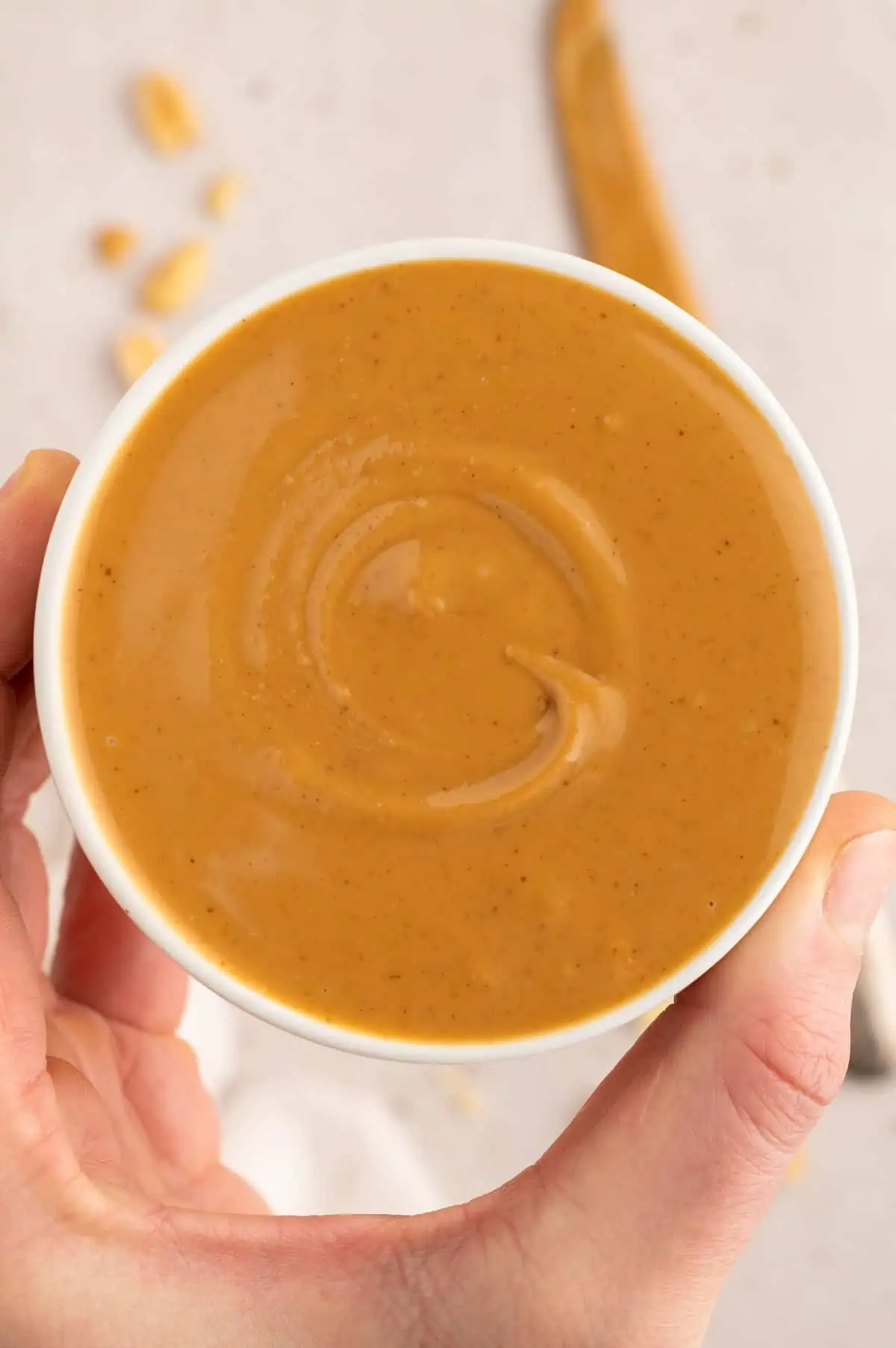 Smooth peanut butter in a ceramic bowl—used as the base for peanut dipping sauce. 