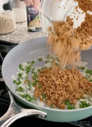 Adding plant-based vegan ground meat into saute pan.