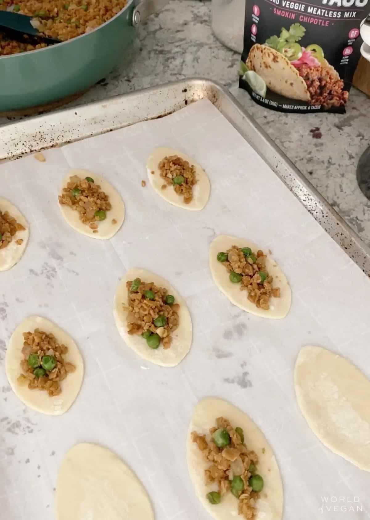 Adding filling to the football pastry dough. 