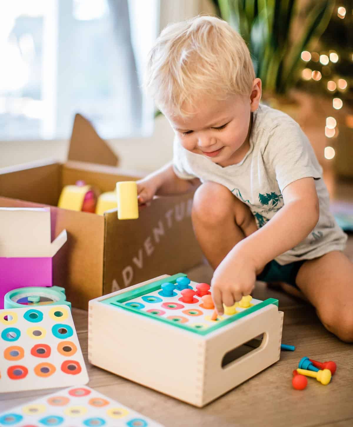 Vegan kid Graham Miller opening and playing with a Lovevery play kit gift.