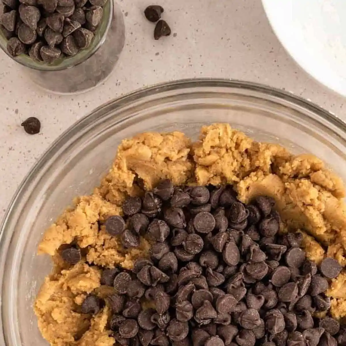 Pile of vegan chocolate chips on top of cookie dough.