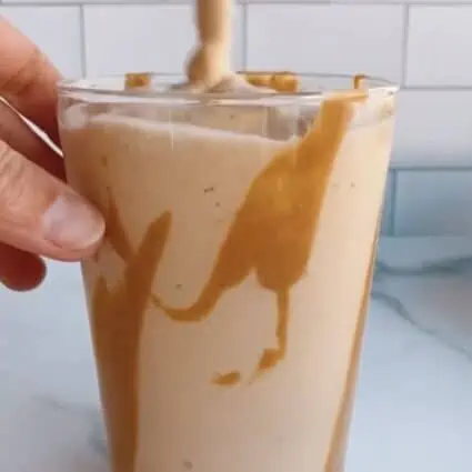 vegan milkshake in a glass with peanut butter drizzle