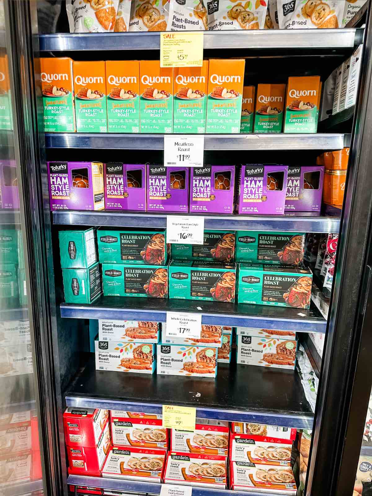 An entire freezer case with several brands of plant-based vegan turkey options at Whole Foods grocery store. 