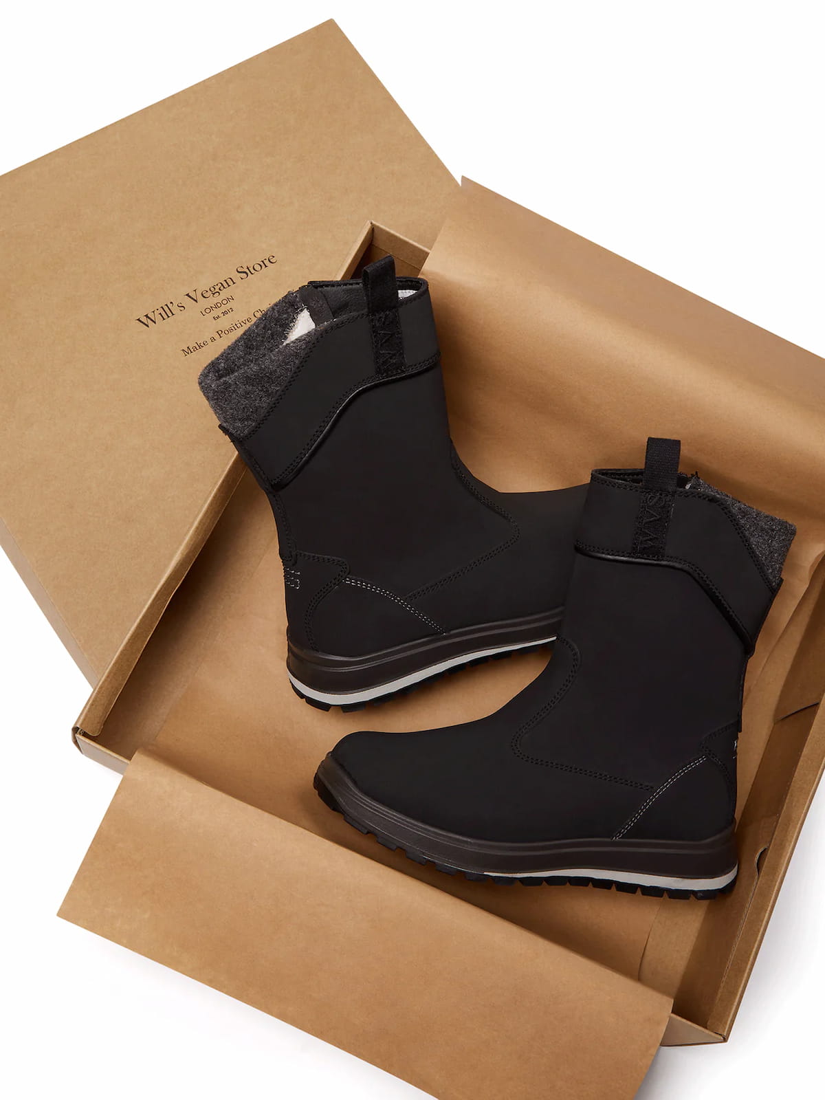 Black Ugg-style vegan boots in a cardboard box.