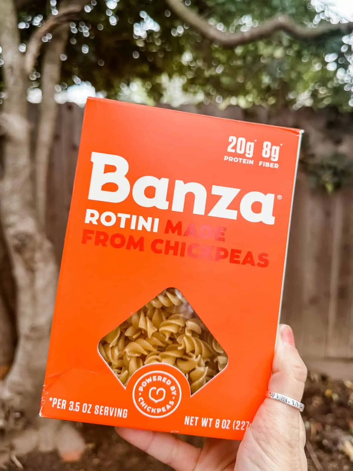 Hand holding up a box of Banza chickpea pasta.
