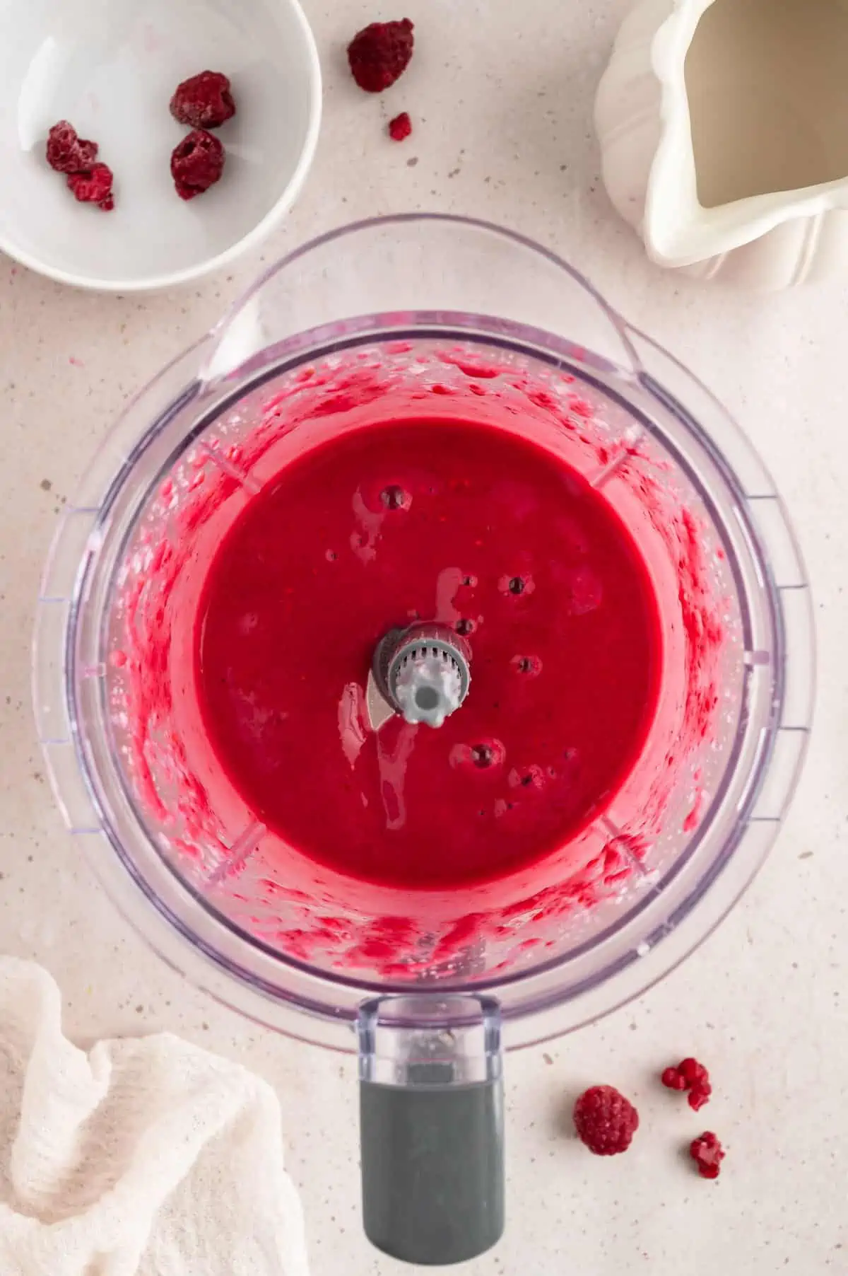 A raspberry smoothie blended in a blender.