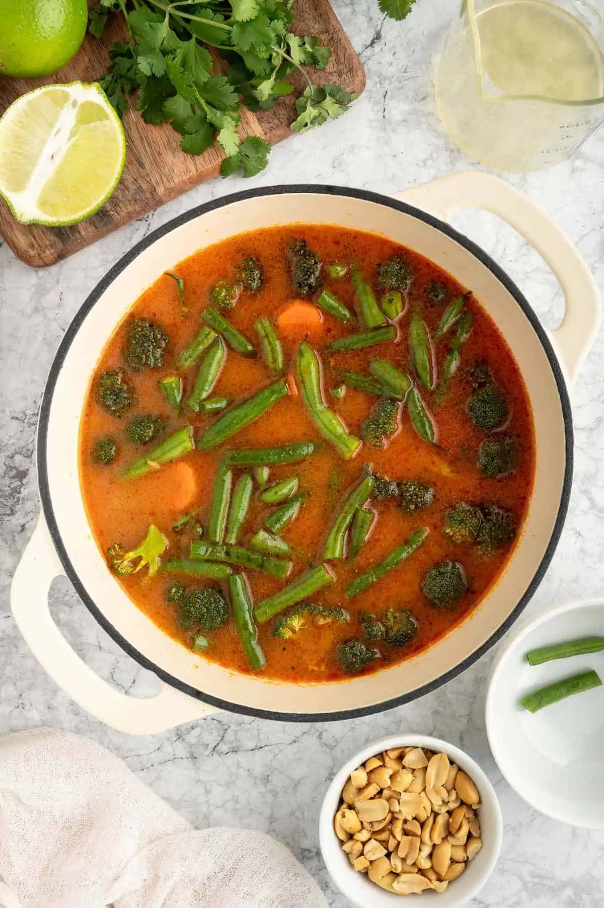 A pot with broth and vegetables simmering inside of it.