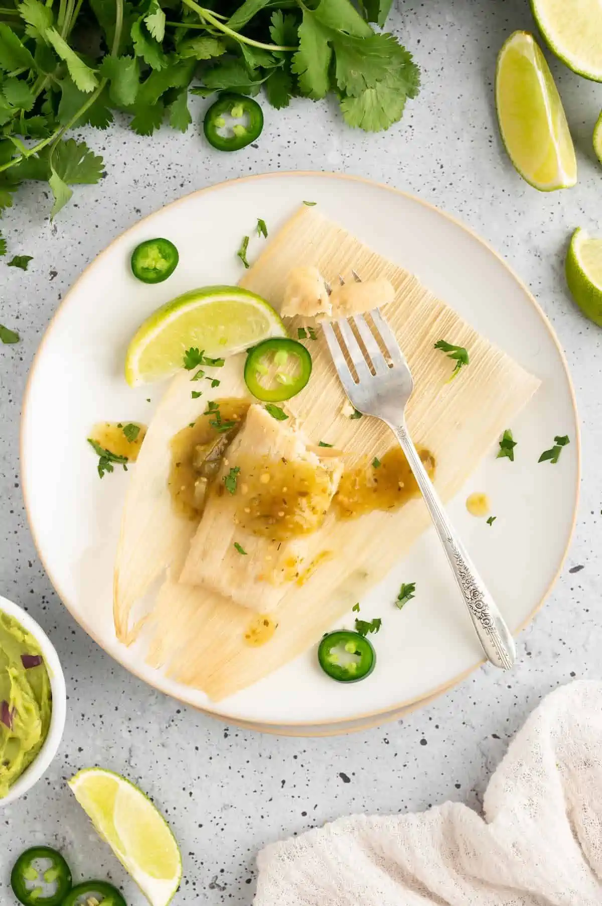 A vegan tamale on a plate, with garnish.