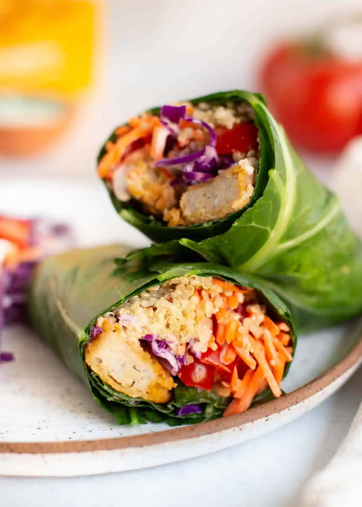 Two collard greens wraps on a plate.