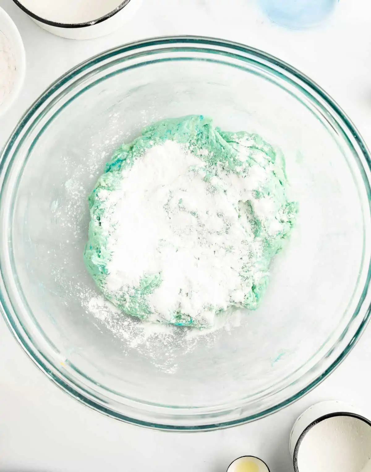 Cornstarch sprinkled onto the dough in a mixing bowl.