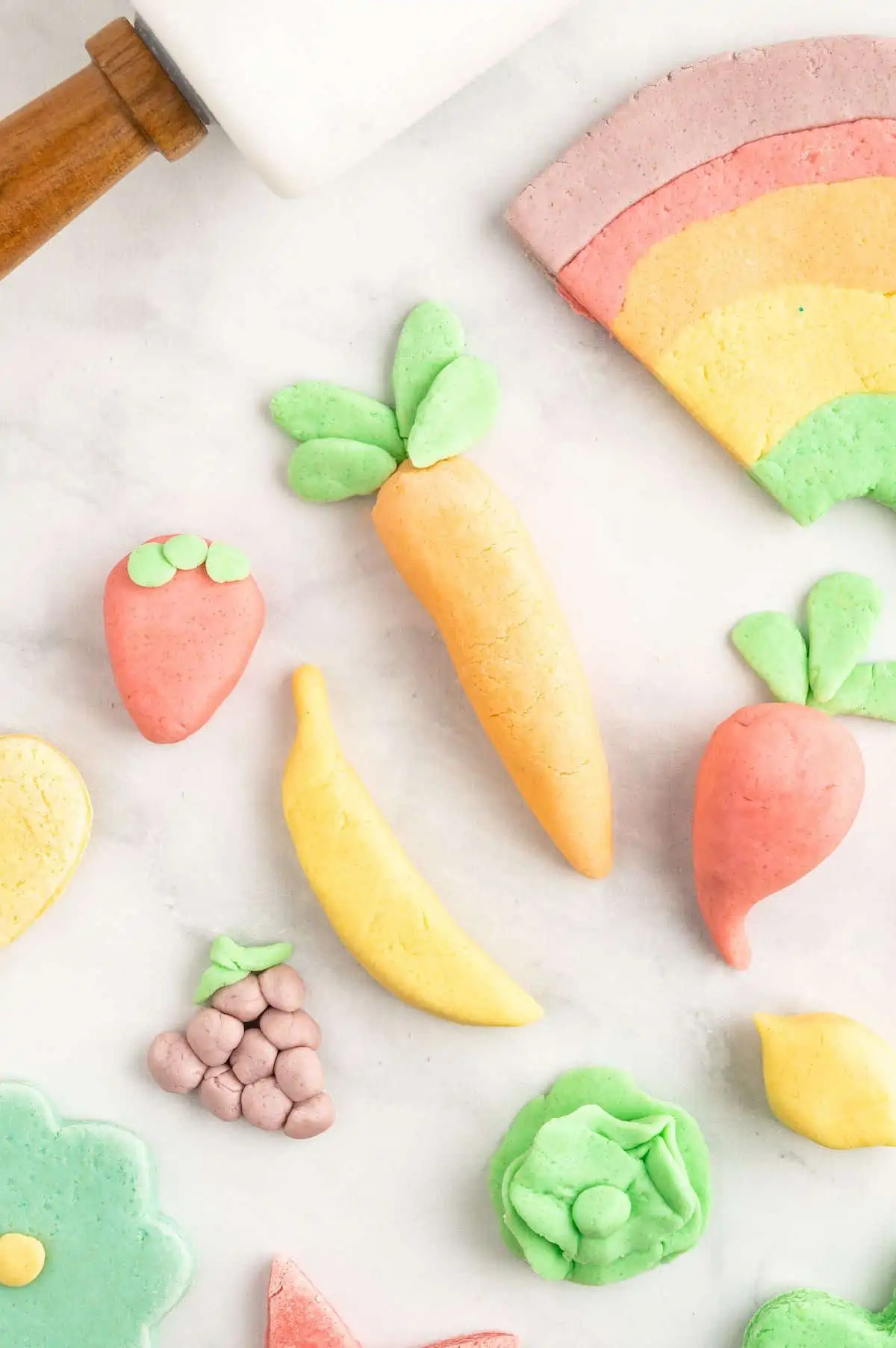 Homemade playdough without cream of tartar made into fruit shapes.