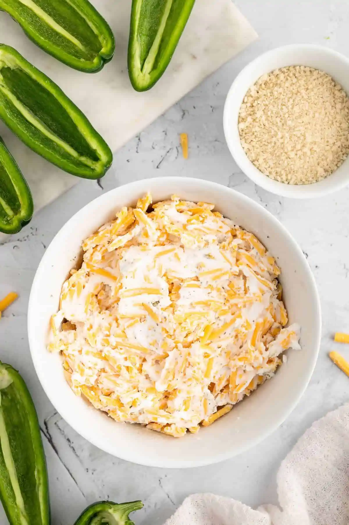 A white bowl with filling for jalapeno poppers.