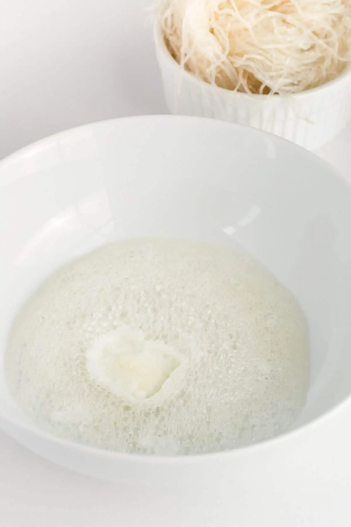 Bowl of fizzing lemon juice and baking soda prepared for kelp noodles to soak in.