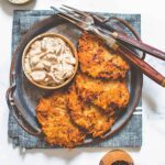 A plate of vegan potato latkes with caramelized onion dip.