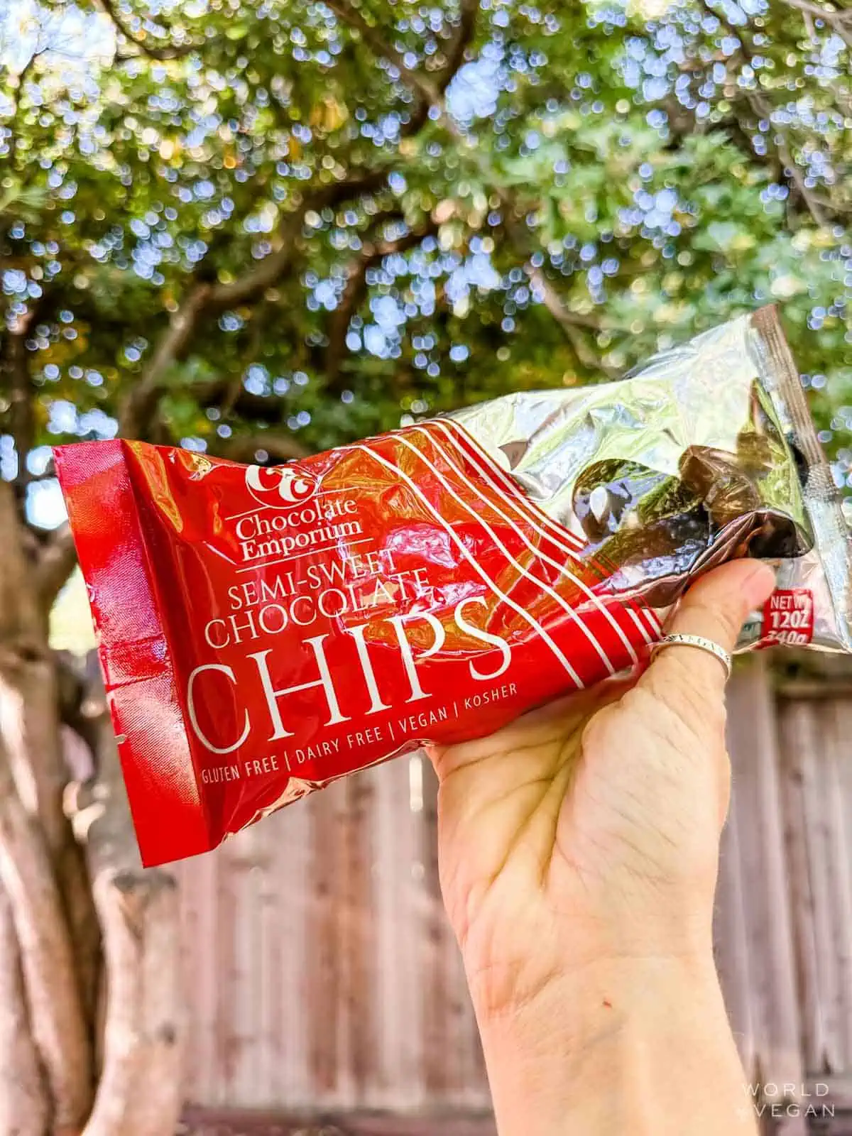 Hand holding up a bag of Chocolate Emporium semi-sweet chocolate chips.