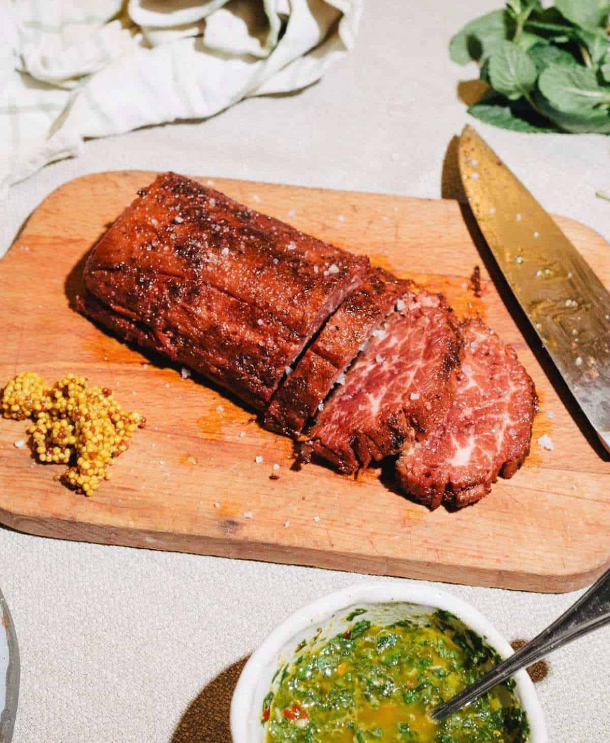 Cutting vegan loin into a flank shape on a cutting board.