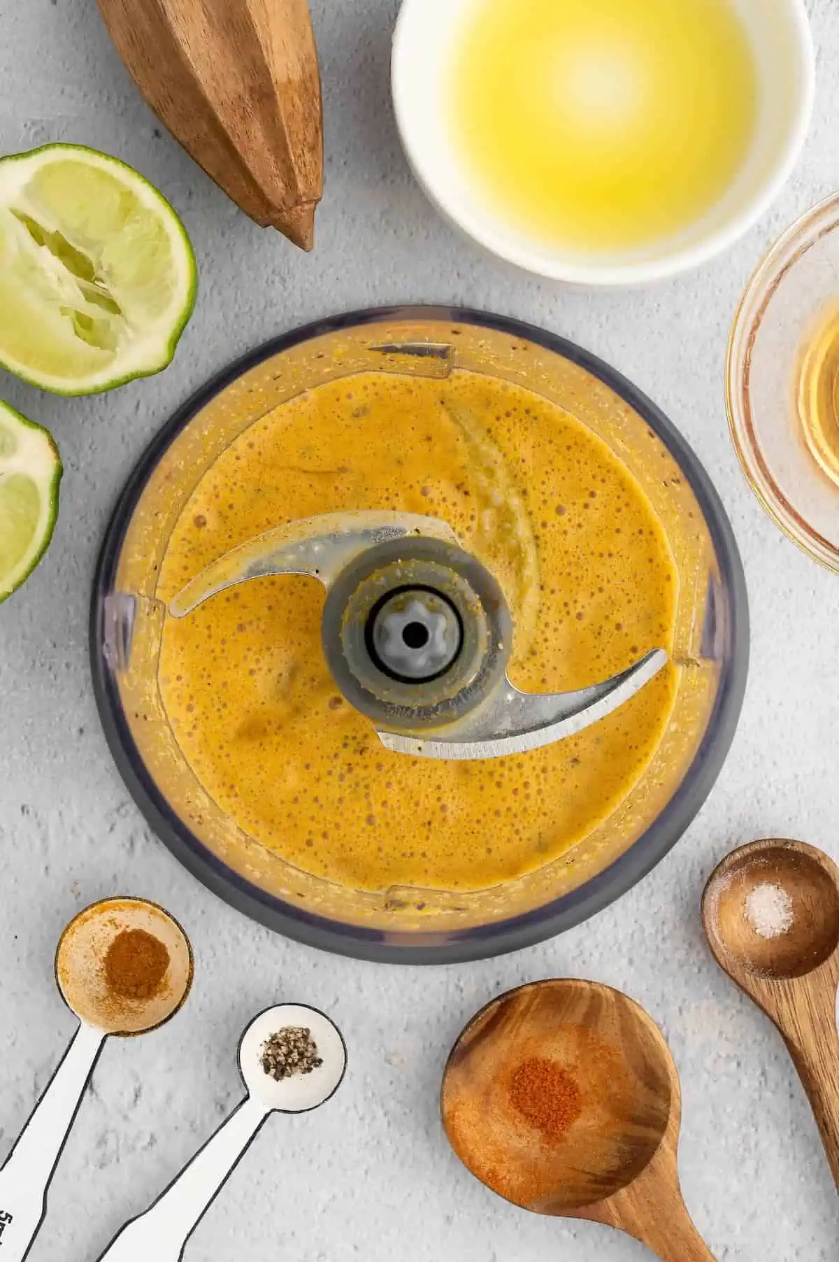 A citrus-turmeric dressing being prepped in a food processor.