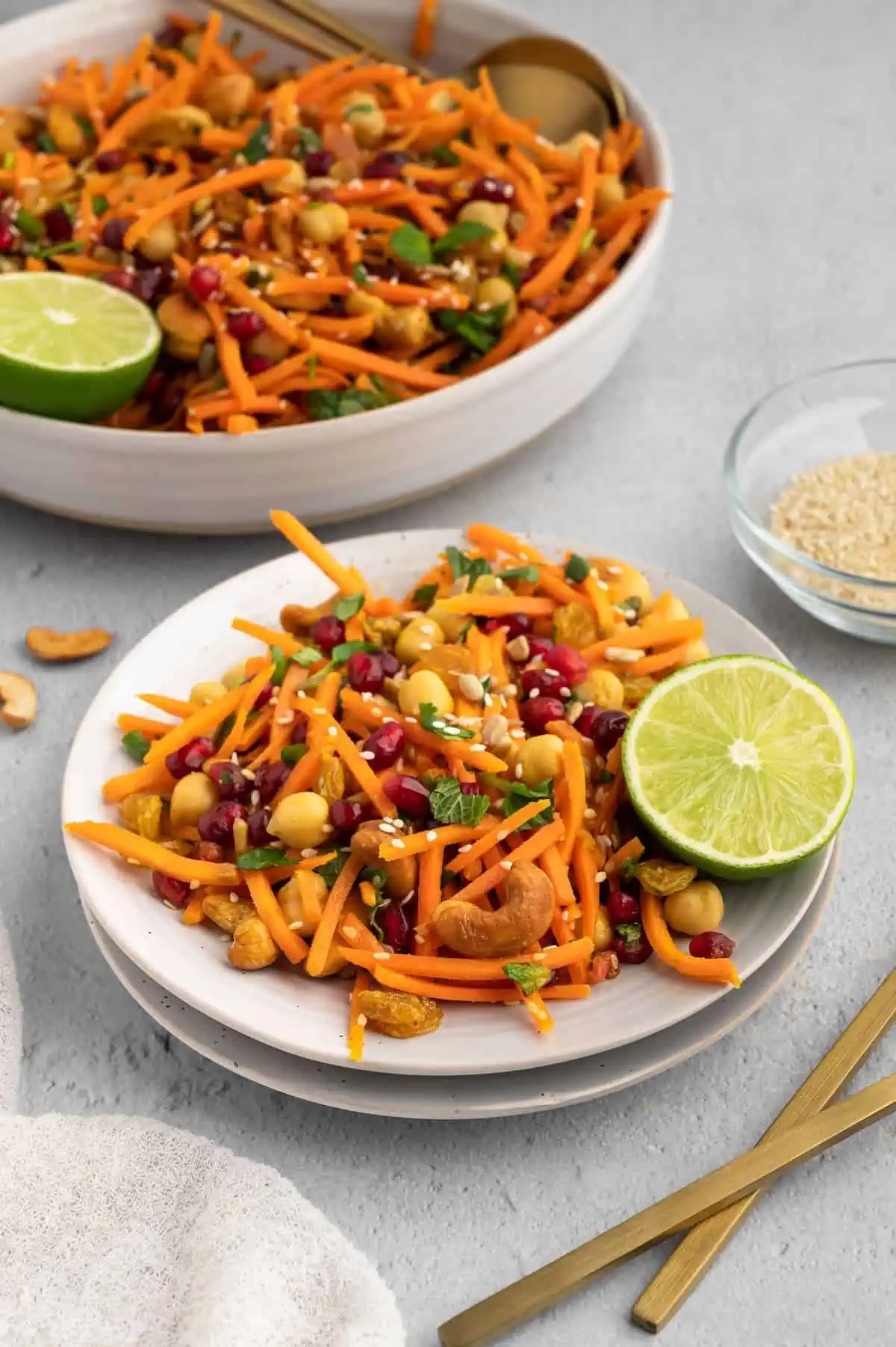A plate of Moroccan carrot salad with a lime wedge.