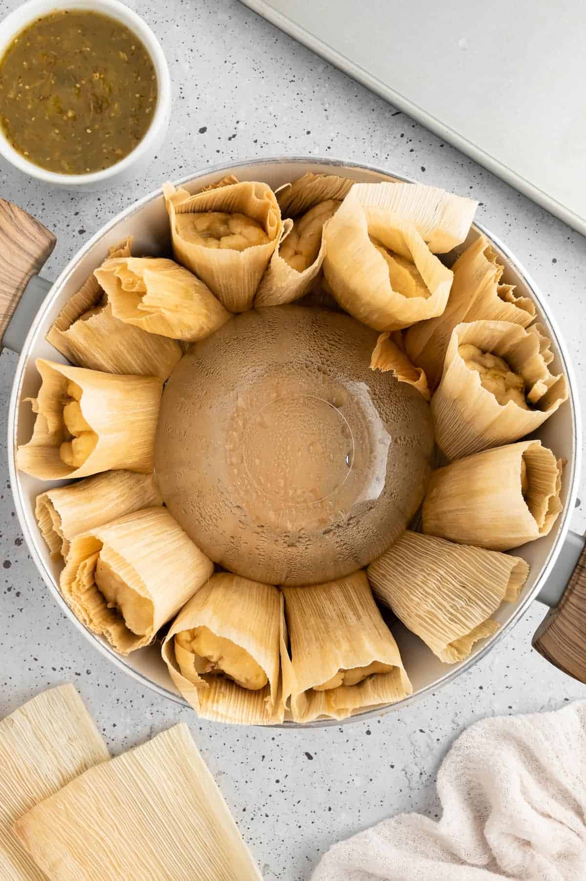 Vegan tamales assembled in a pot to be steamed.