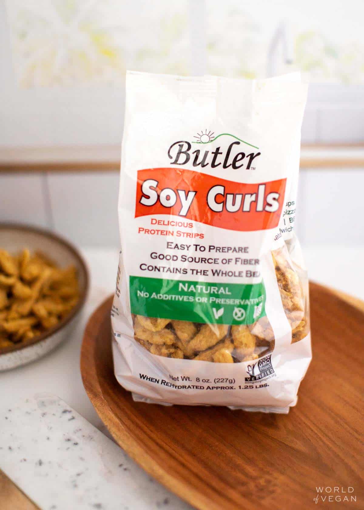 A bag of Butler brand soy curls vegan meat made from soybeans on a wooden tray.