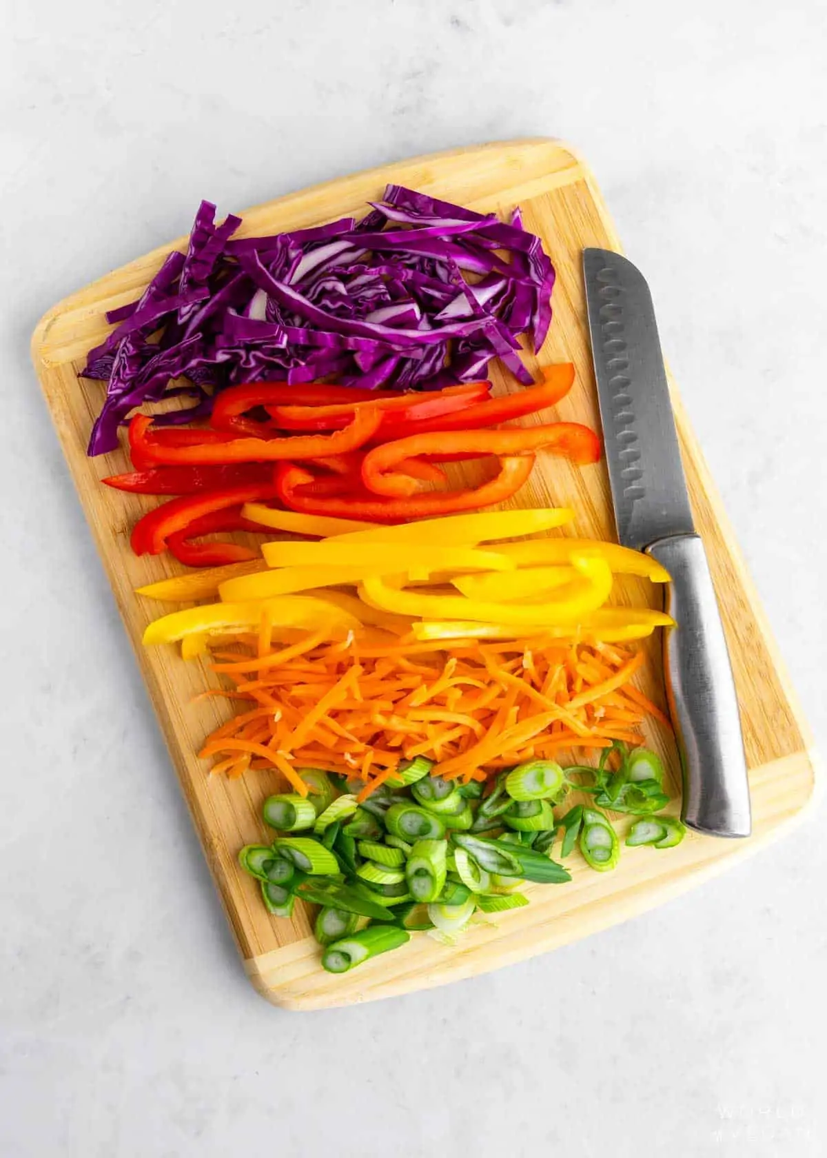 Chopped rainbow vegetables with red, orange, yellow, green, purple. 