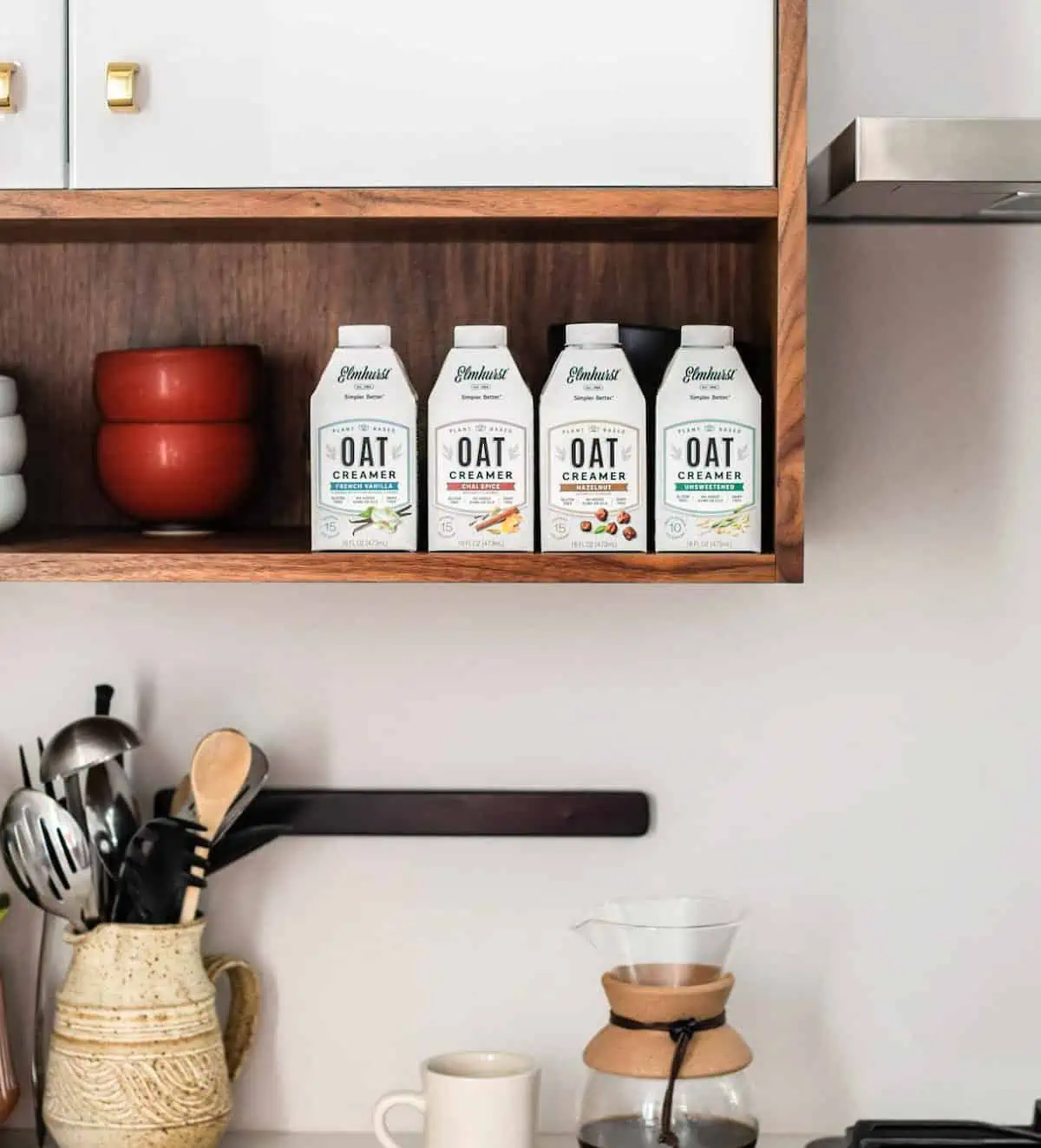 Elmhurst oat coffee creamers in a row on a shelf.