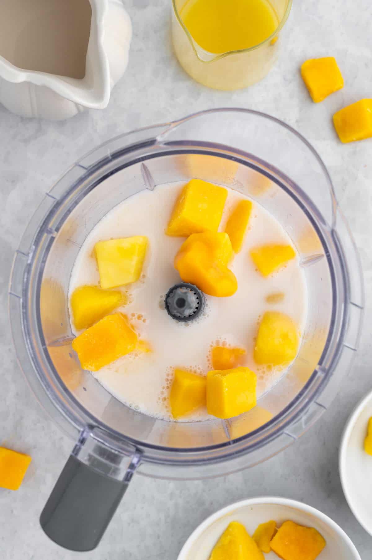 Ingredients for the mango pineapple smoothie added to the blender pitcher.