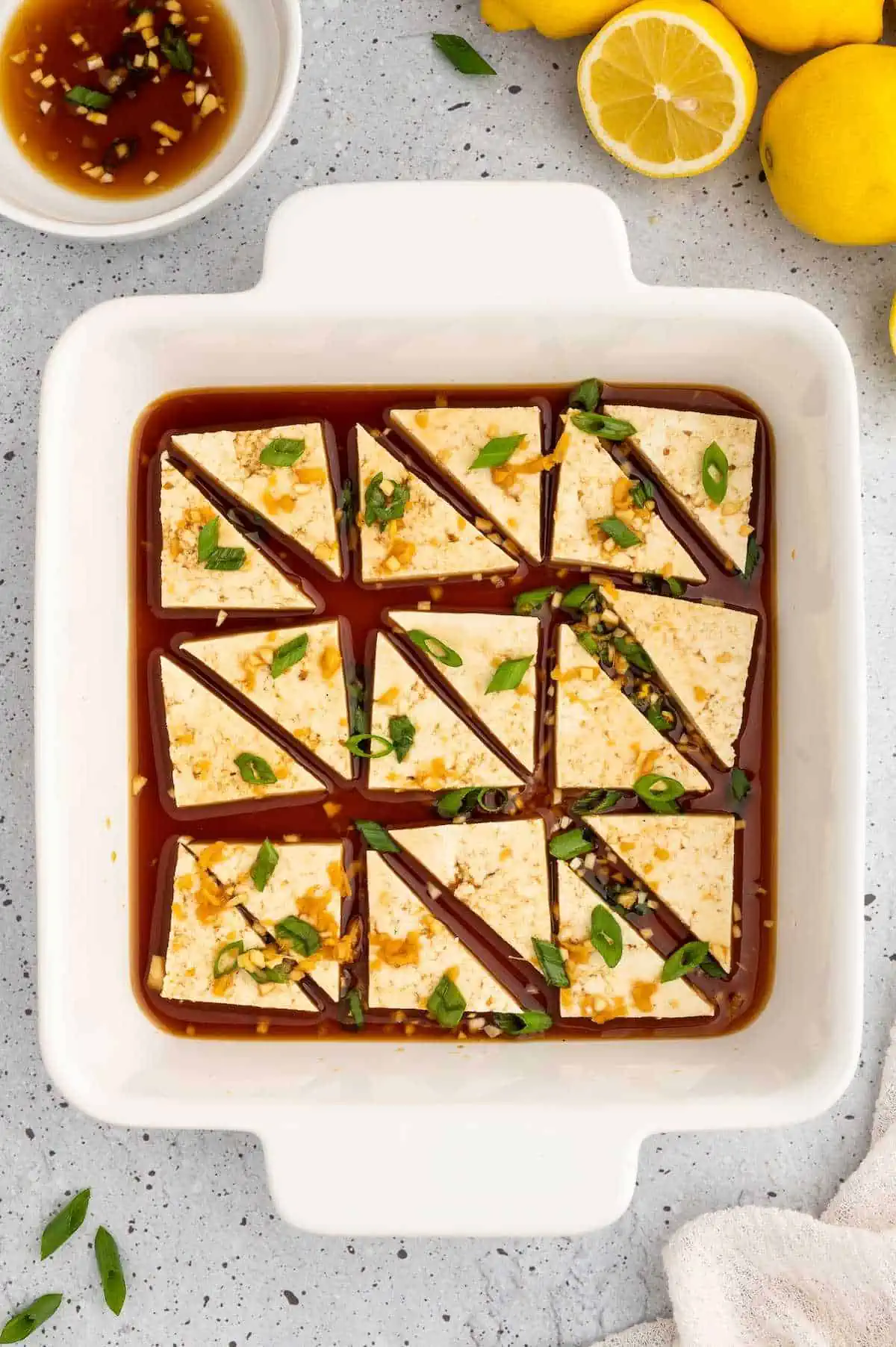 Tofu triangles marinating in asian tofu marinade.