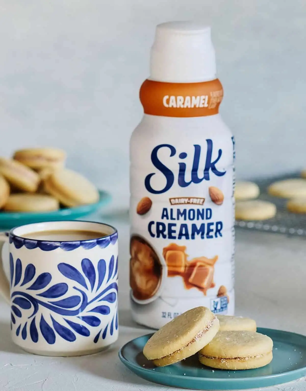 Silk Caramel Almond Creamer beside a mug and plate of cookies.