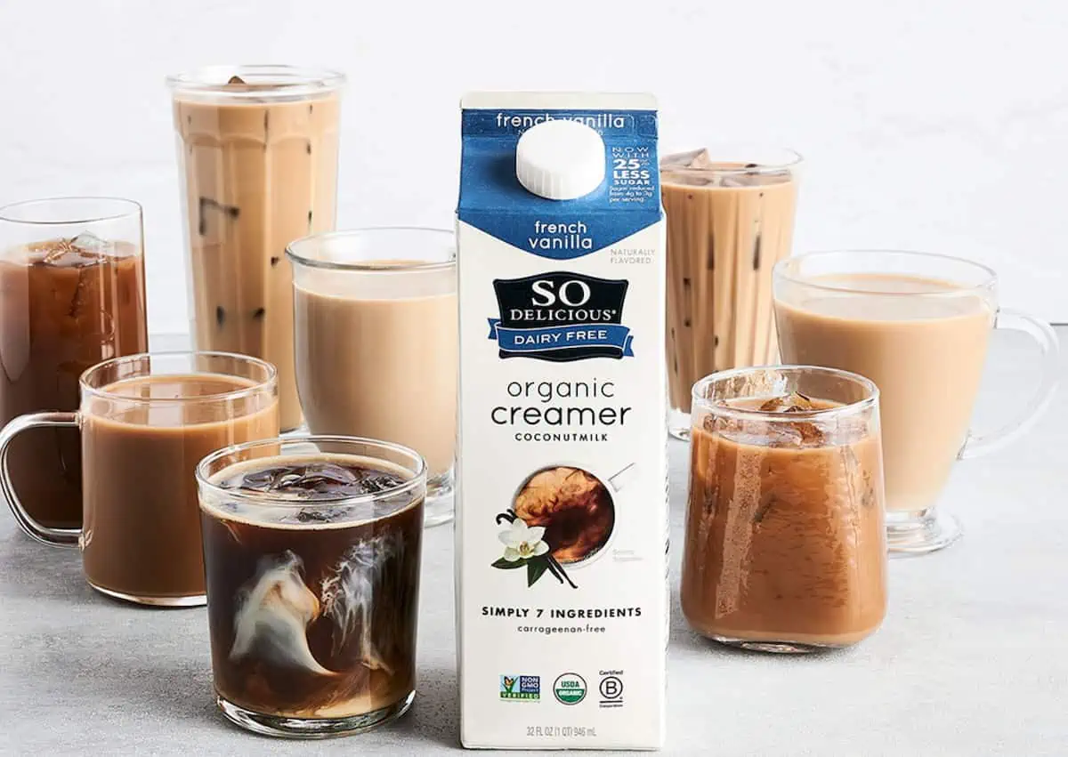 So Delicious dairy-free coffee creamer carton beside several glasses of coffee drinks.