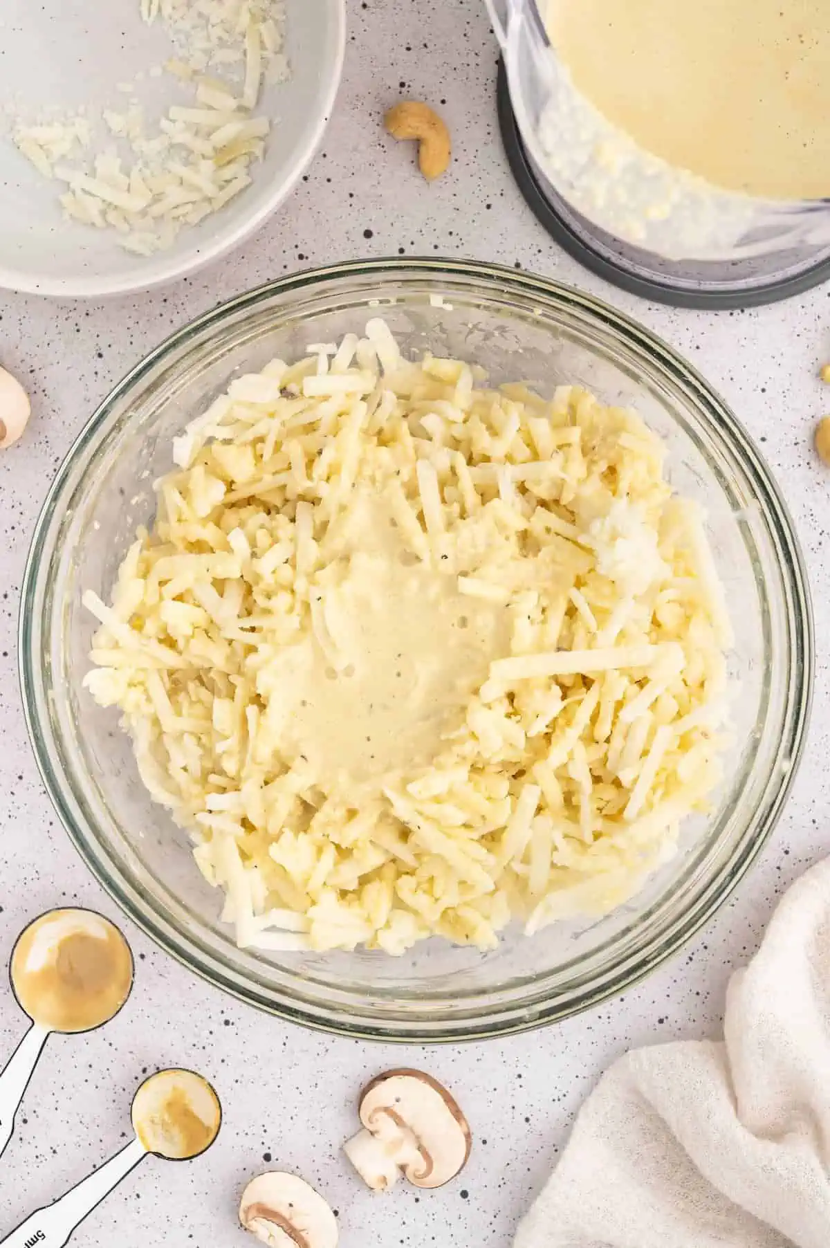 Vegan cheese sauced mixed with hash browns in a bowl.