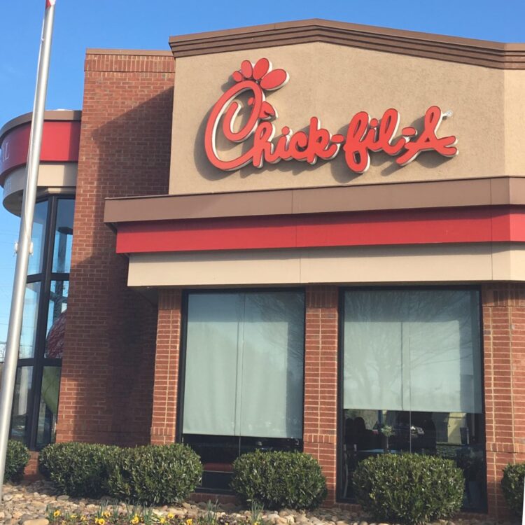 View of the front of a Chick Fil-a restaurant with the sign logo in front.