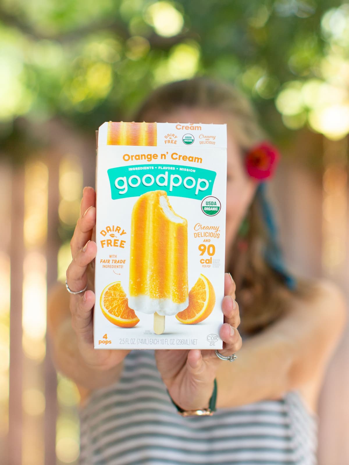 hands holding box of orange cream goodpop ice cream