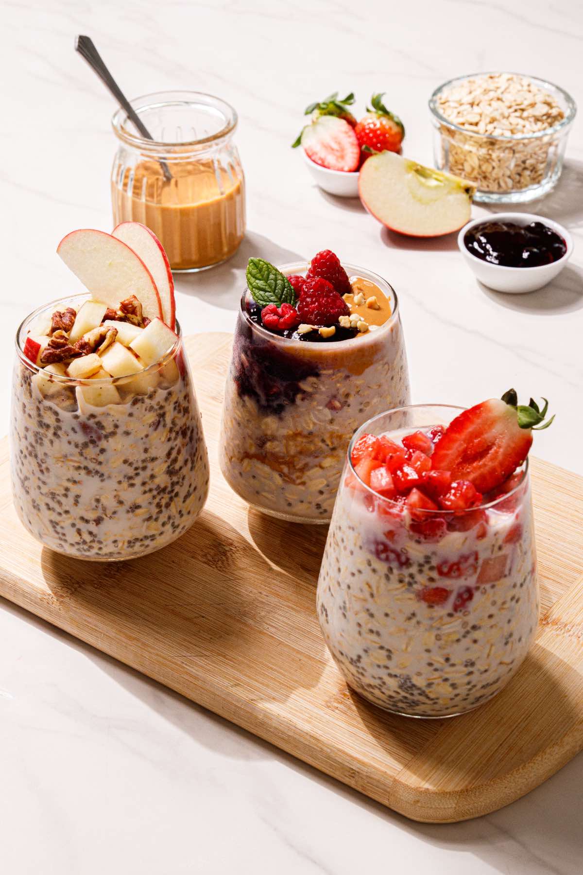 Different types of overnight oats with fruit, peanut butter, chia seeds, and other add-ins.