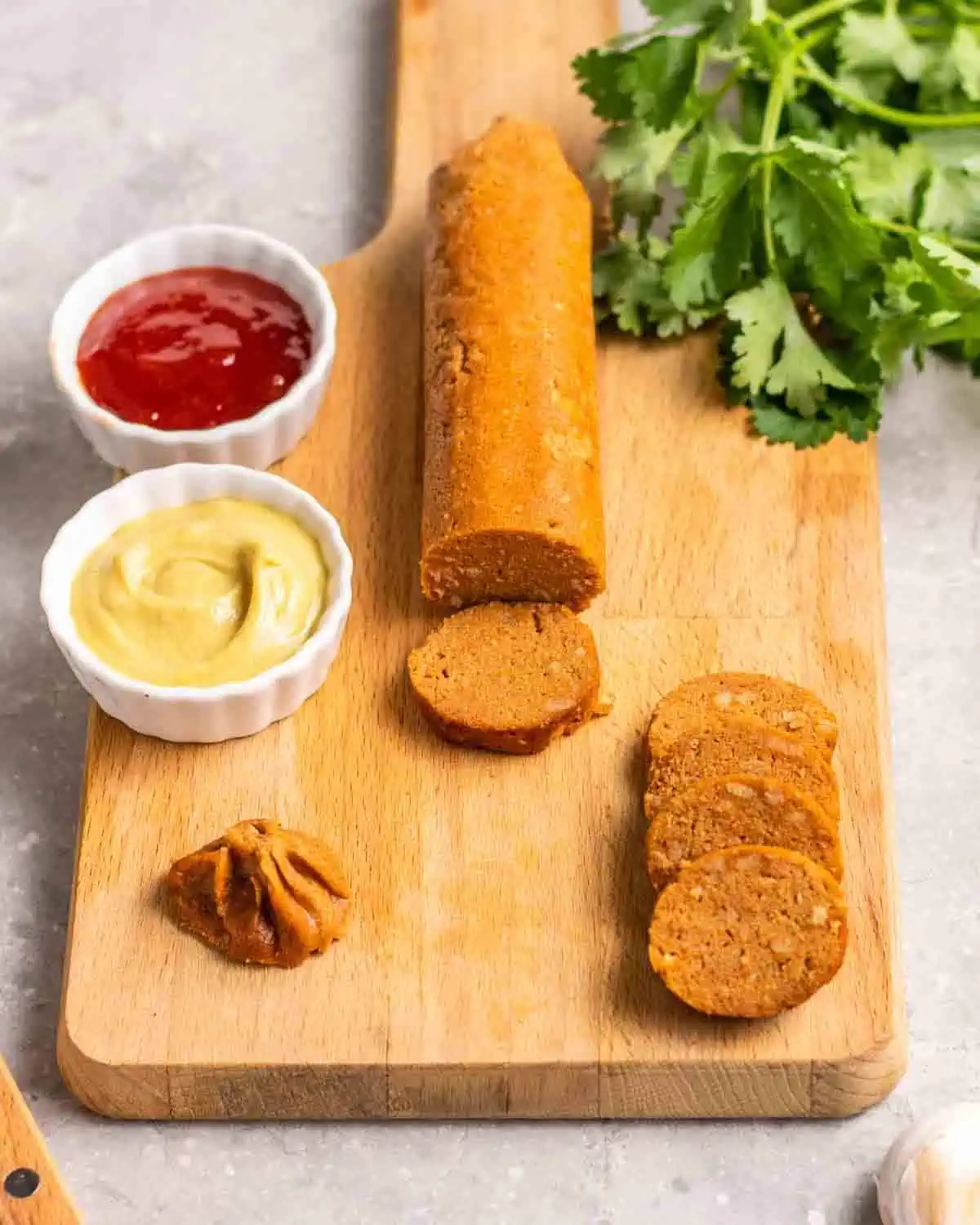 Vegan seitan sausage sliced on a cutting board.