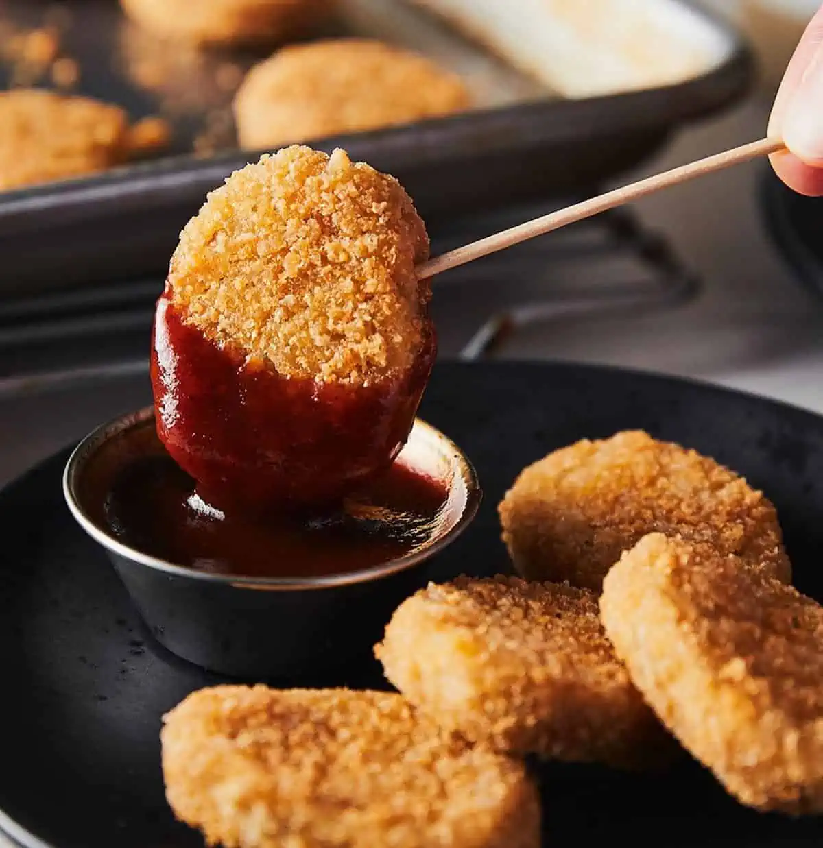 Field roast brand vegan chicken nuggets, dipped in sauce.