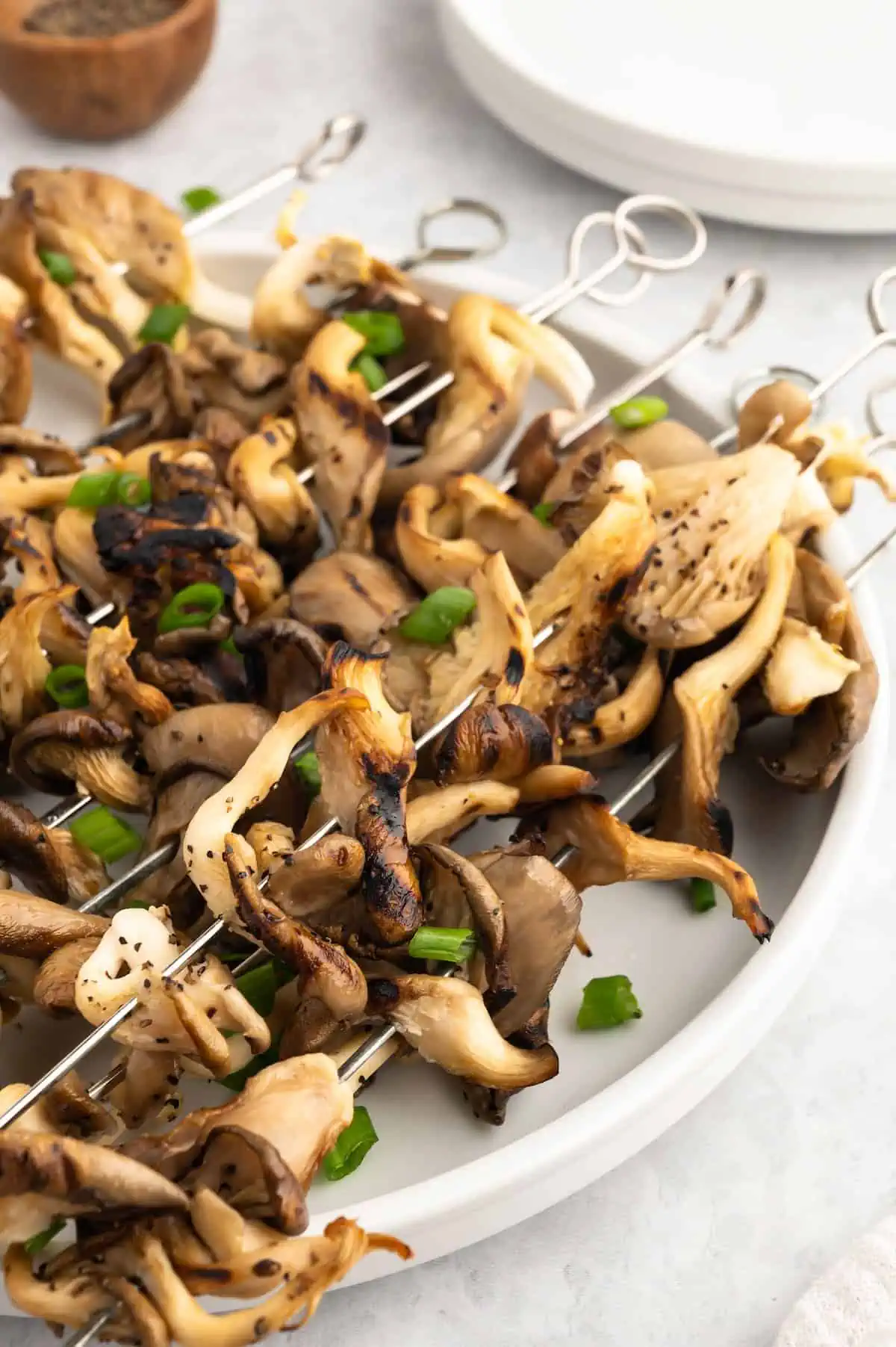 A plate loaded up with grilled mushroom skewers.