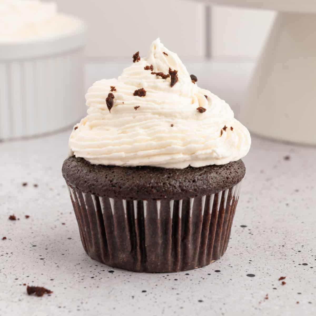 Vegan chocolate cupcake topped with buttercream frosting and chocolate shavings.