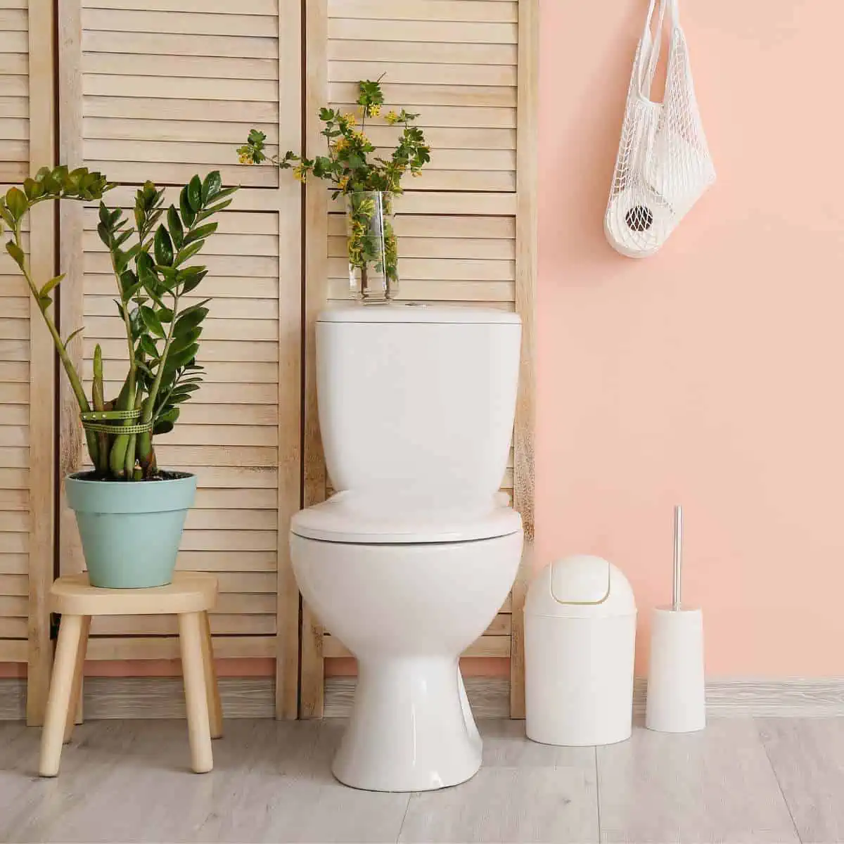 Cruelty-free bathroom with a toilet, plants, and cleaning brush.