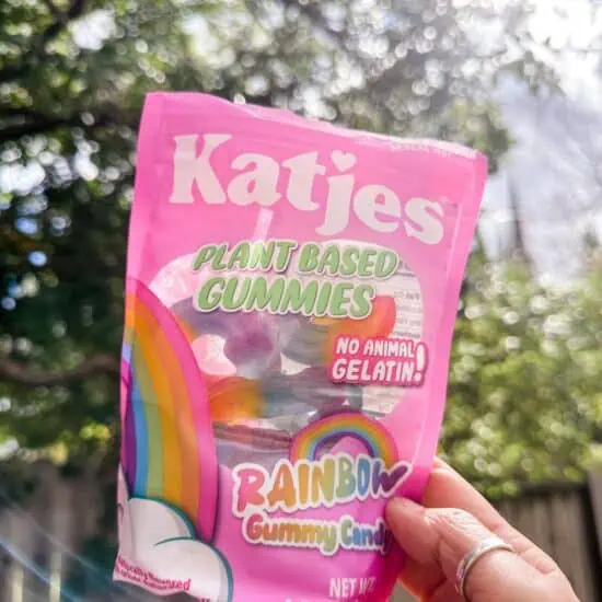 Woman holding up a bag of Katjes rainbow unicorn gelatin-free vegan gummies.