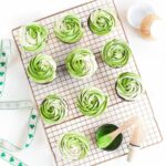 Vegan matcha buttercream cupcakes, arranged on a cooling rack.