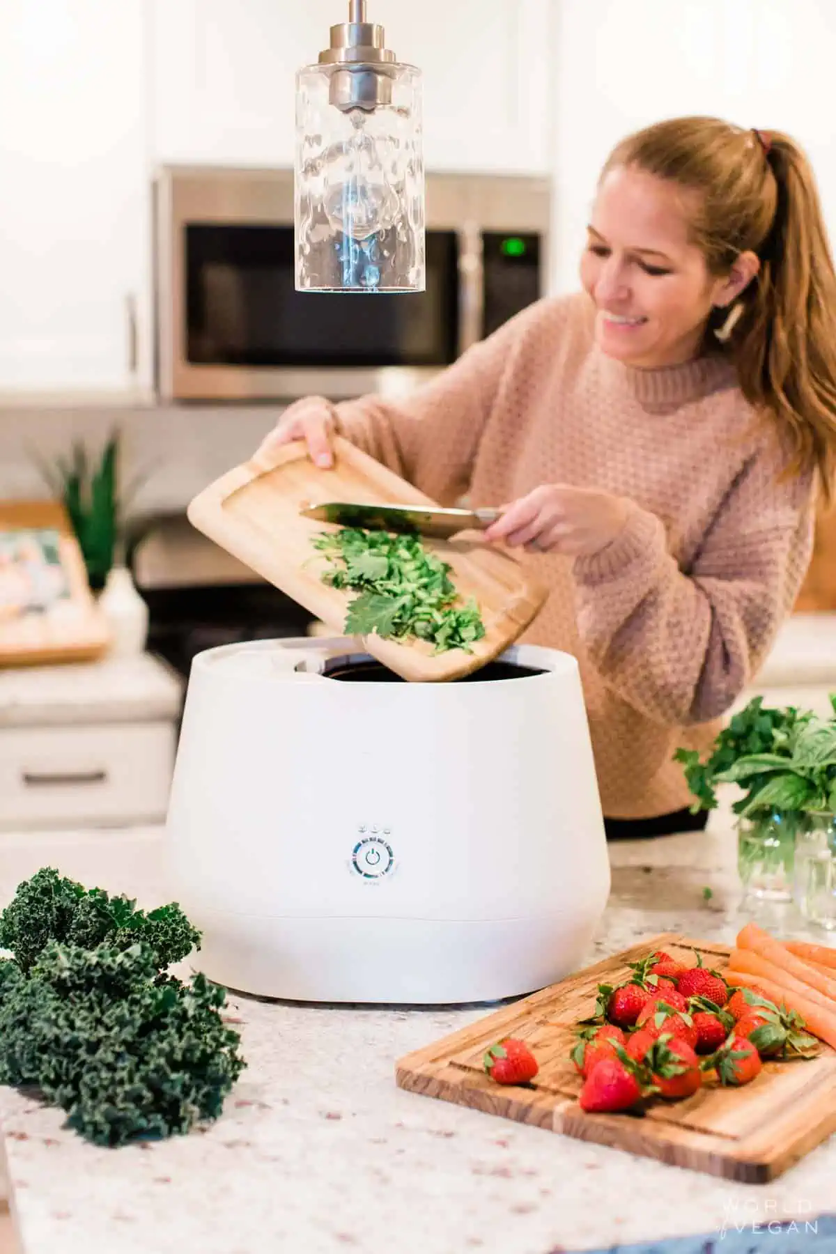 Michelle Cehn adding organic waste food scraps into the Lomi kitchen composter. 