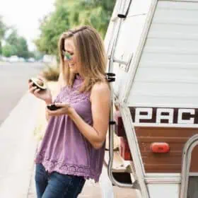 Michelle Cehn leaning against a RV Van with an avocado.