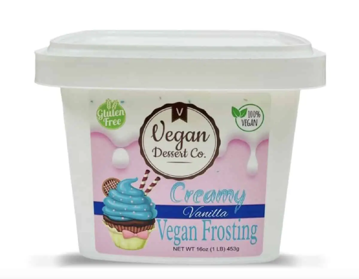 A pink and white tub of Vegan Dessert Company creamy vanilla frosting against a white background.