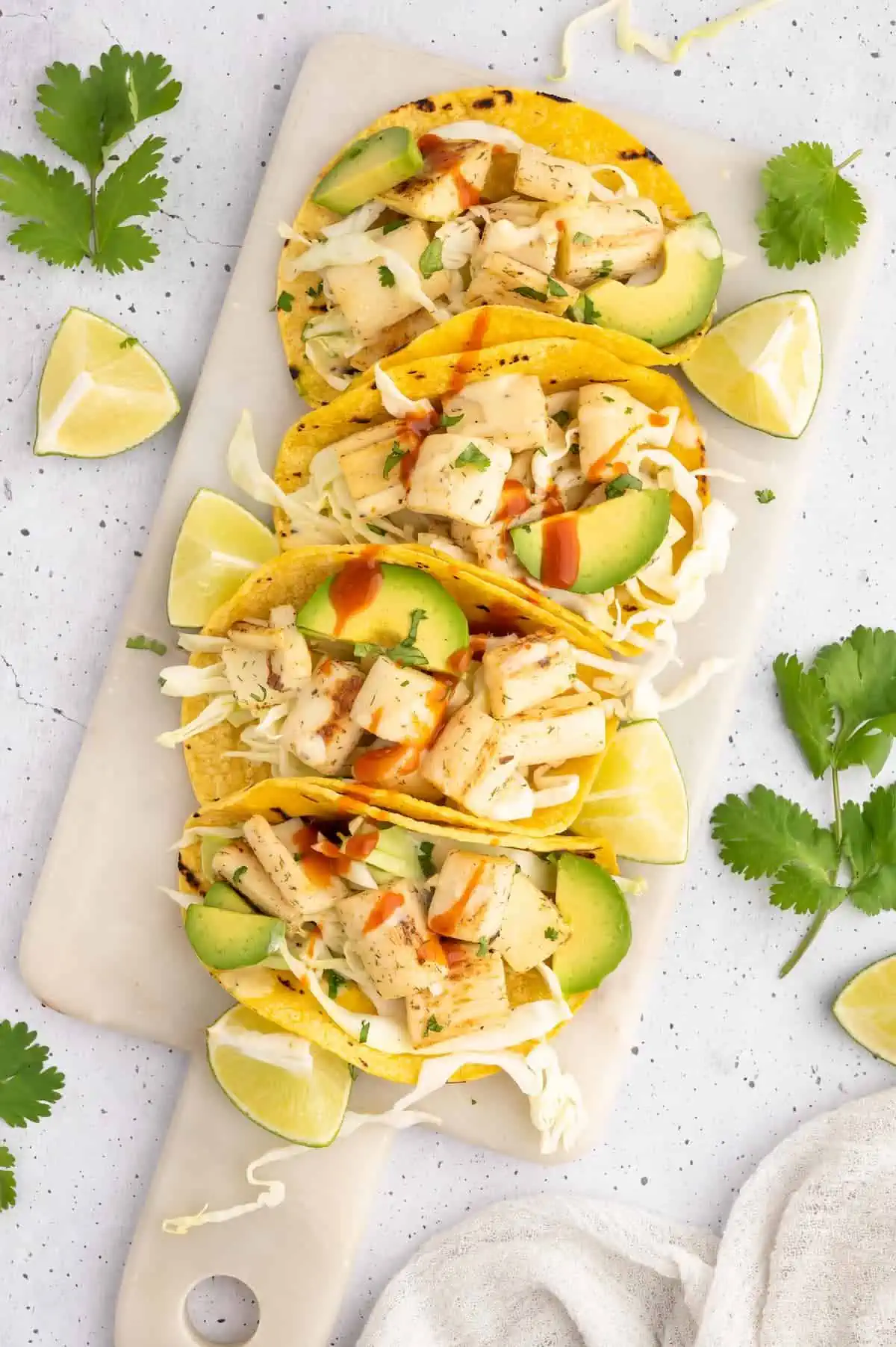 Vegan fish tacos lined up on a serving platter.