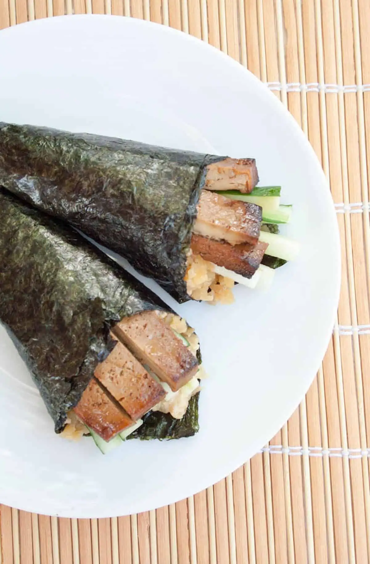 Two baked tofu hand rolls on a plate.