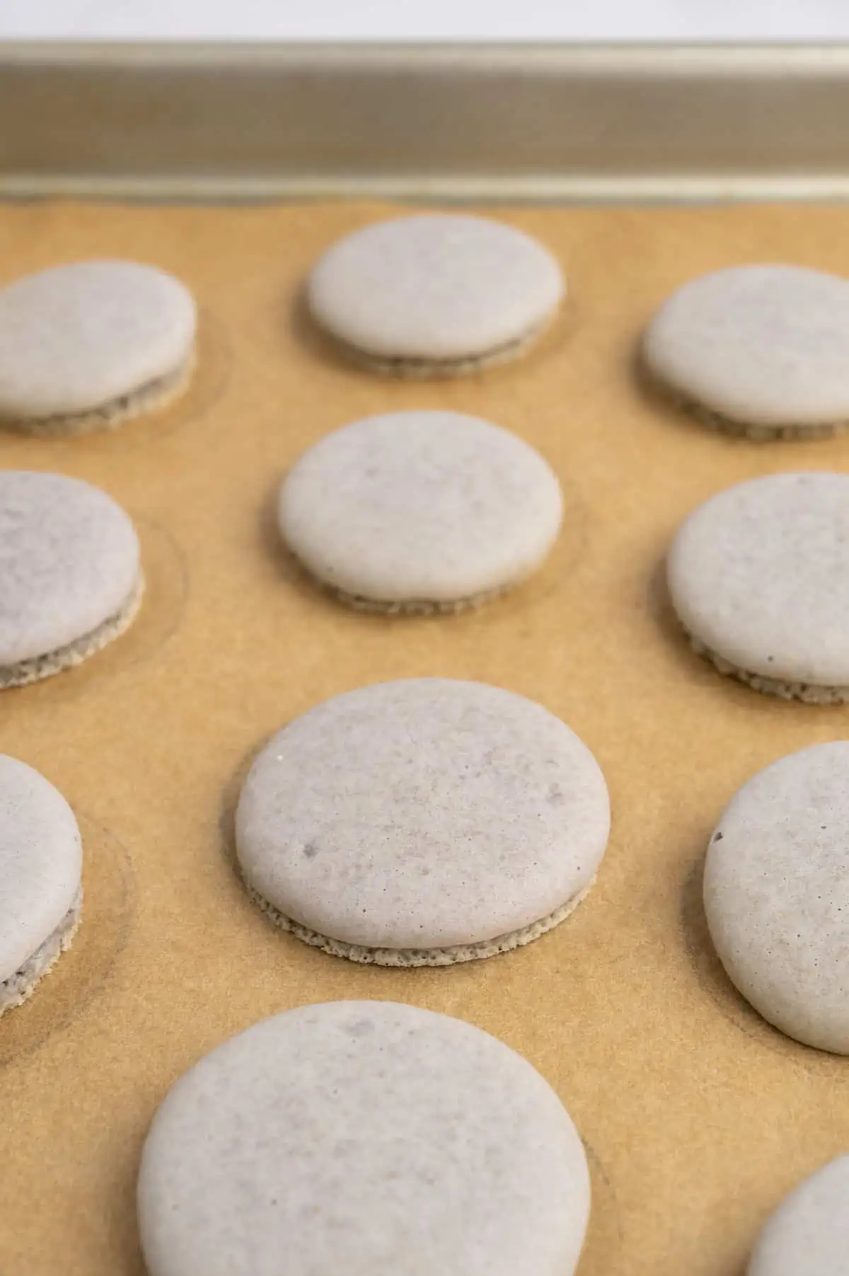 Baked vegan macaron shells on a baking tray.