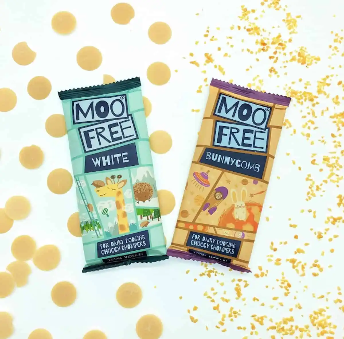 Moo Free White Chocolate bars on a light background surrounded by pieces of white chocolate.