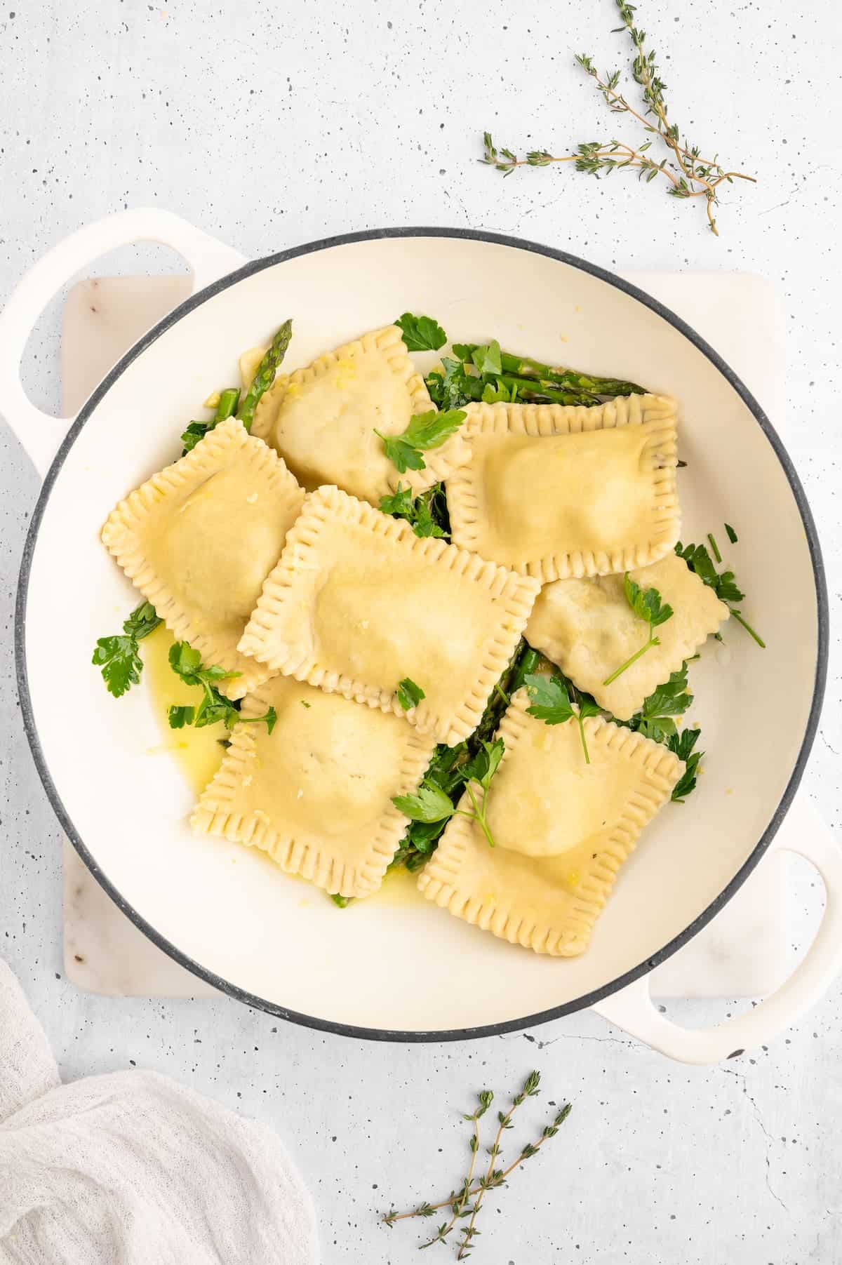 Vegan ravioli in a pan with asparagus.